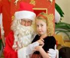 Девушка разговаривает с Санта-Клаусом на коленях